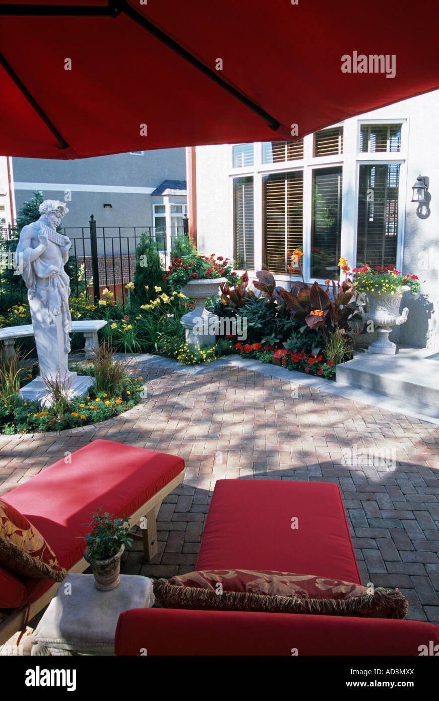 MINNEAPOLIS, MINNESOTA TOWNHOME patio giardino con la statua di PAN TERME, banco HADDENSTONE, canna gigli e erbe giapponese. Foto Stock