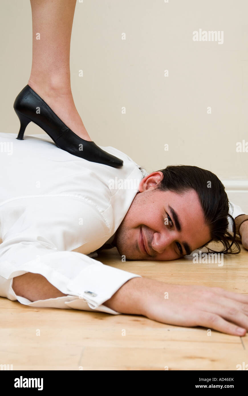 L'uomo sul pavimento sotto i piedi femminili Foto Stock