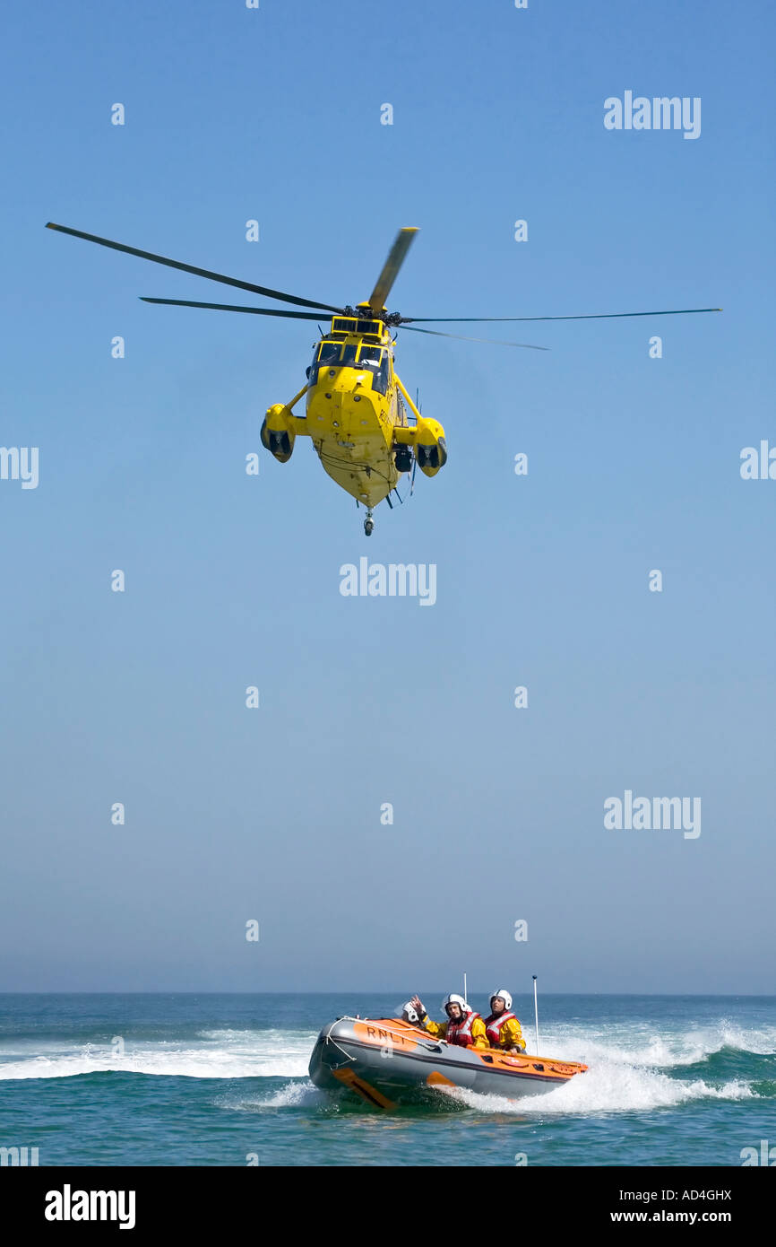 RNLI Cromer Inshore scialuppa di salvataggio con un RAF rescue Sea King elicottero Foto Stock