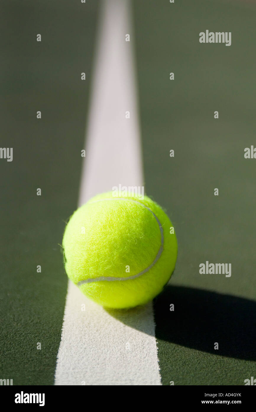 Una palla da tennis giacente su una linea bianca Foto Stock