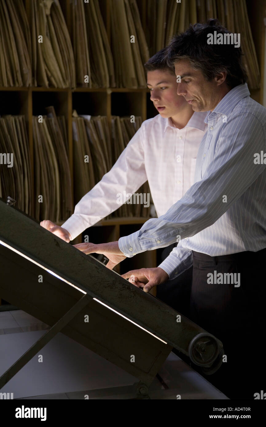 Due imprenditori in piedi su una scatola di luce in un ufficio Foto Stock