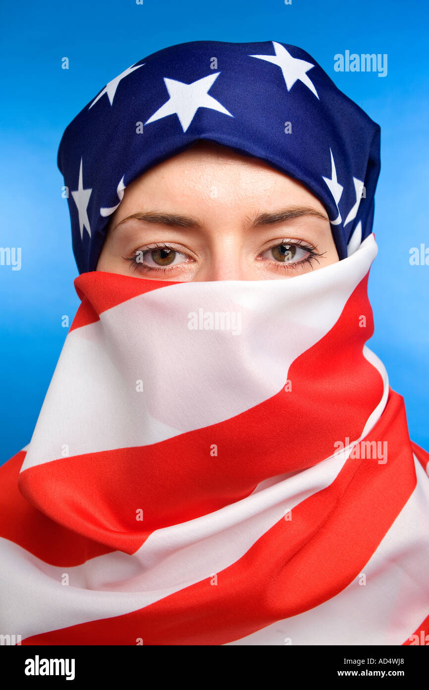 La donna musulmana che indossa un americano USA USA, bandiera come hijab burqa con uno sfondo blu Foto Stock