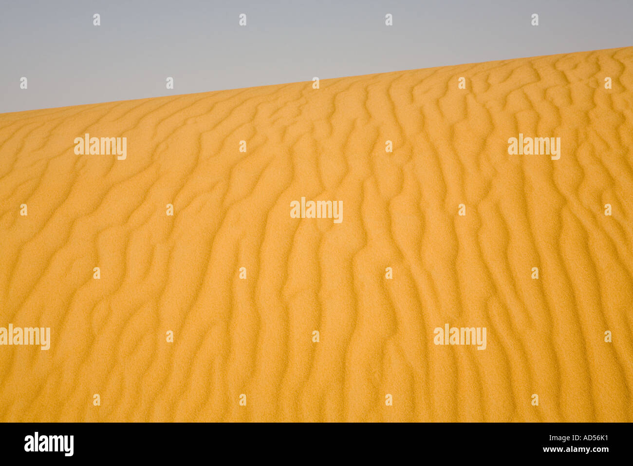 Vista attraverso la formazione di dune forme astratte con sabbia e cielo, in rotta verso Gilf Kebir, deserto del Sahara. L'Egitto. Foto Stock