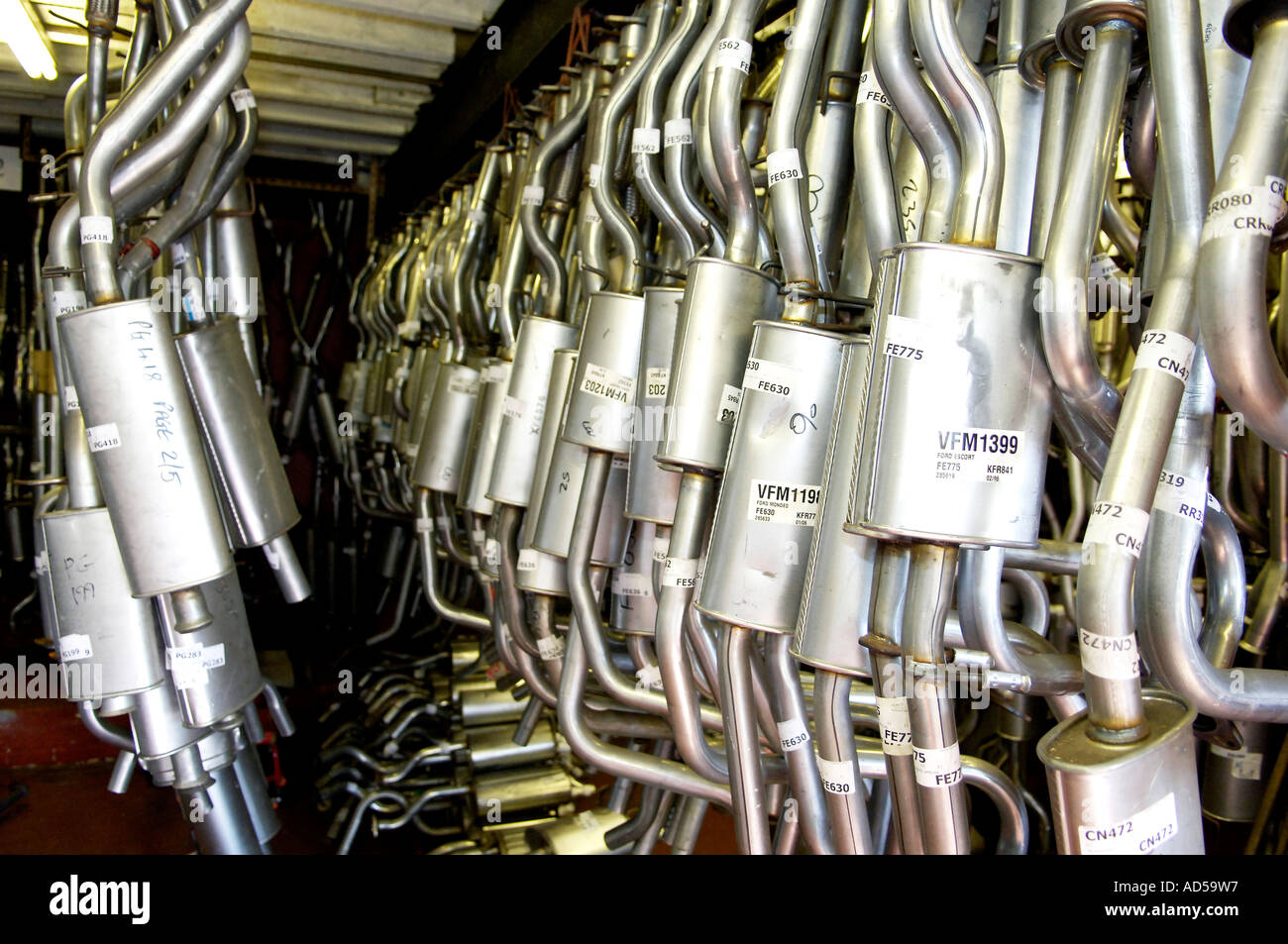 Auto sistemi di scarico appeso nel magazzino dei pezzi di ricambio motore shop Foto Stock
