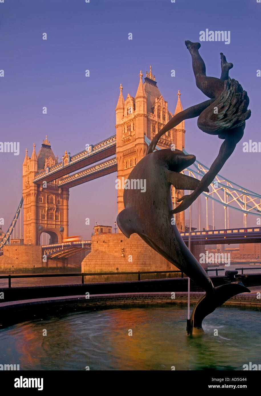 Il TOWER BRIDGE misty dawn sunrise ragazza e Dolphin statua all'alba con il Tower Bridge dietro London REGNO UNITO Foto Stock