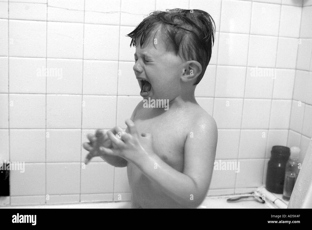 Bambino piangere in vasca con sapone in occhi. Vita documentario Foto stock  - Alamy