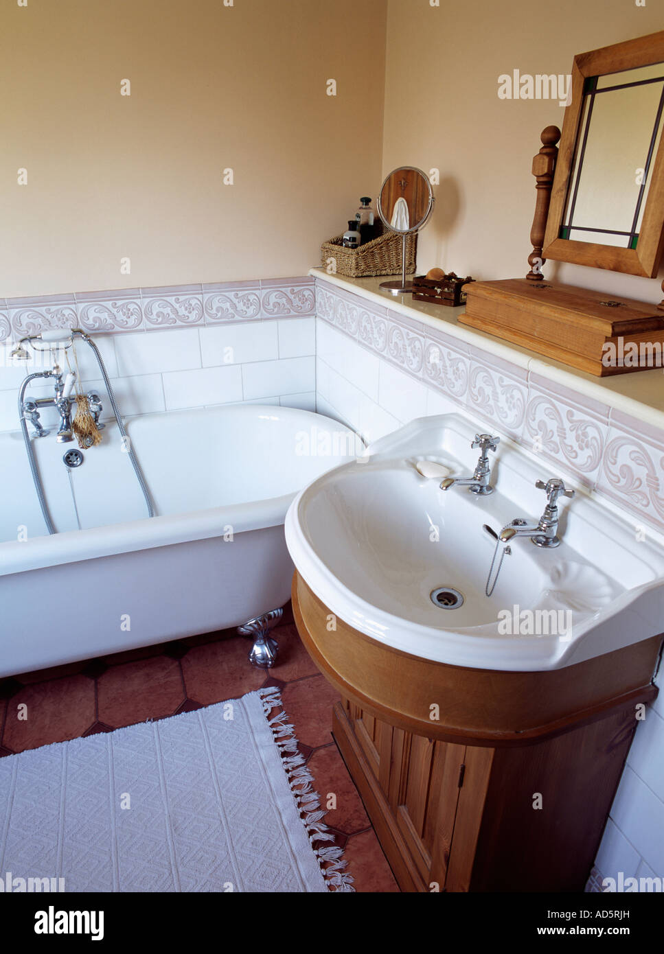 White disegno a rilievo bordo piastrellato in stanza da bagno separata con vasca bianca e vasca realizzata in legno scuro unità dello specchietto di cortesia Foto Stock
