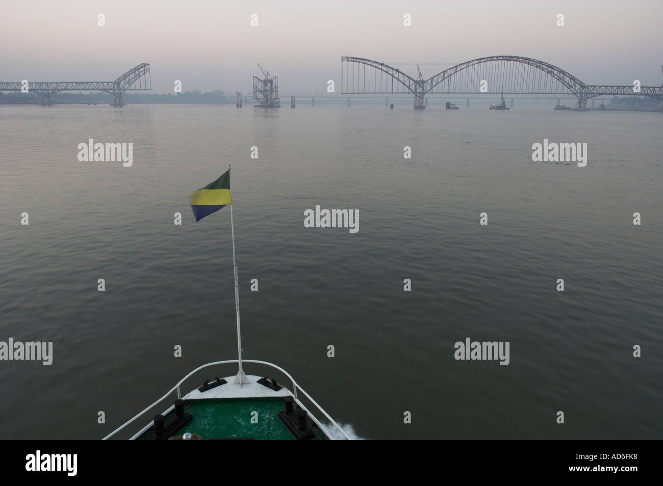 Myanmar Birmania Ayeryarwady fiume vicino a Mandalay ponte sito in costruzione vista al tramonto visto da una barca Foto Stock