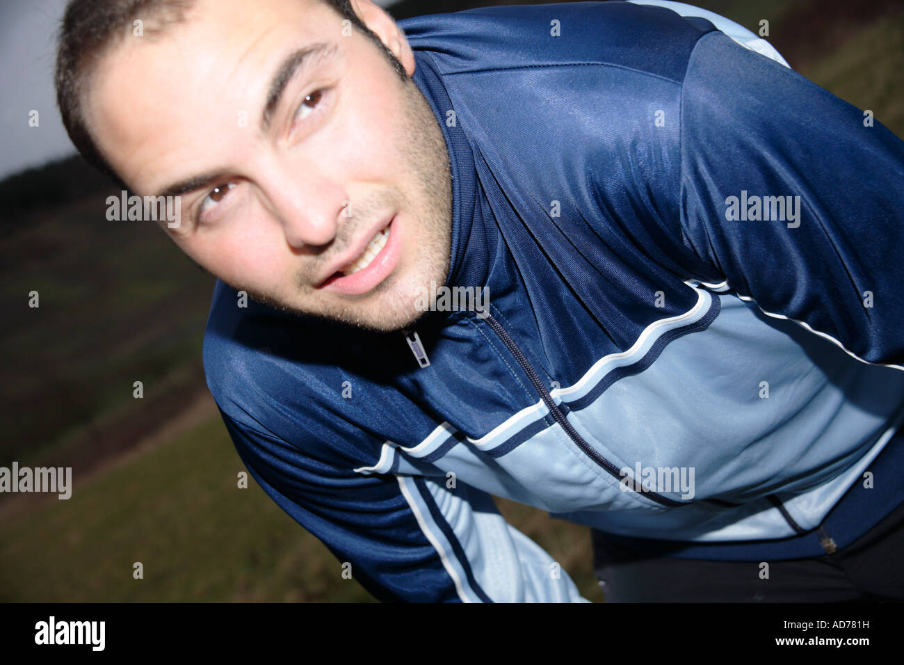 Giovane uomo stretching dopo il jogging in un giorno di pioggia Foto Stock