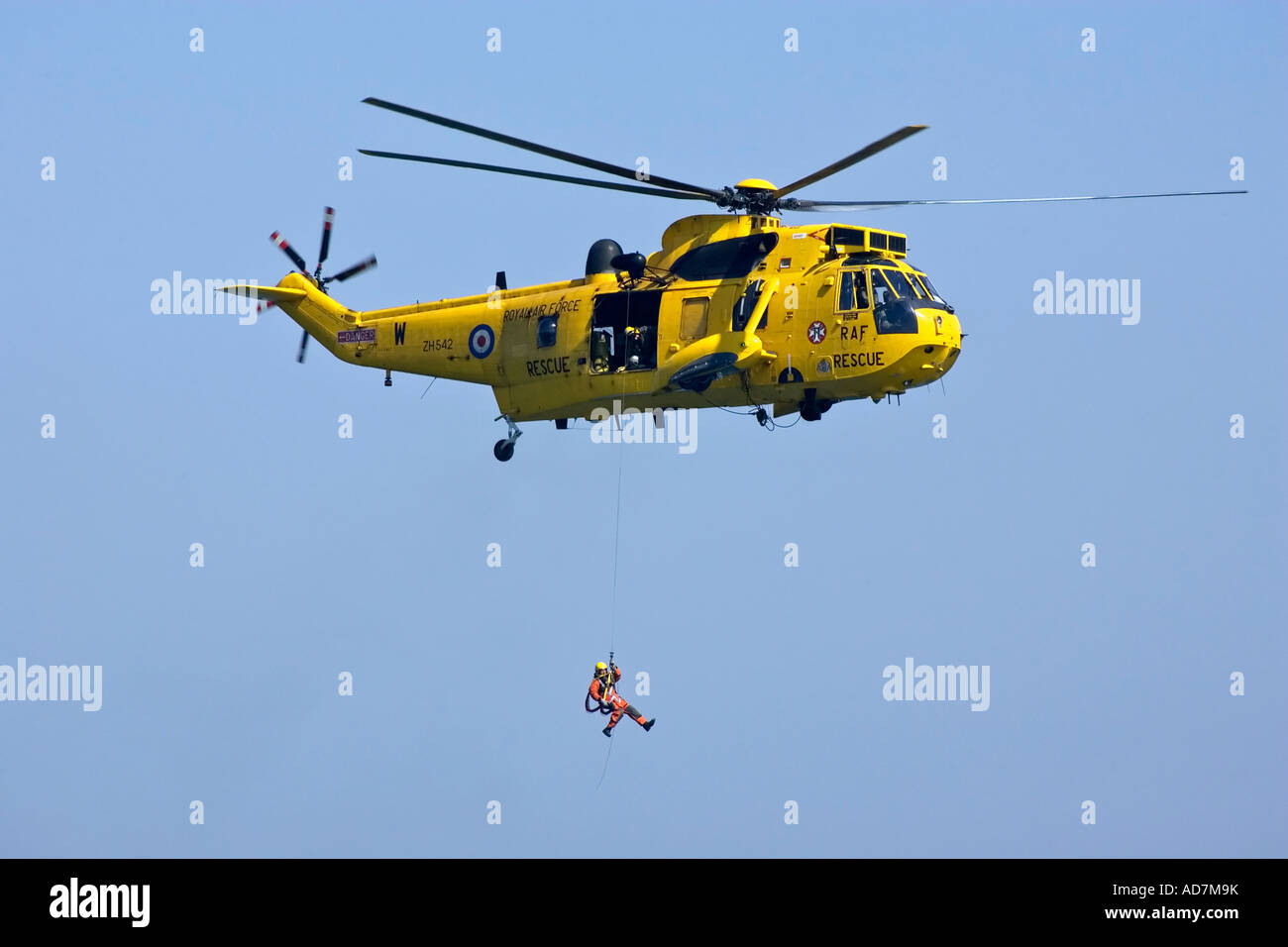 Un mare di RAF Re Salvataggio in elicottero di soccorso con winchman distribuito e andando verso il basso sul cavo del verricello Foto Stock