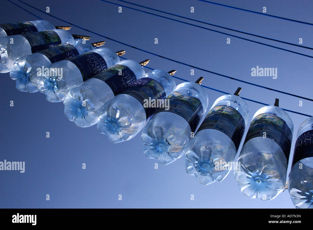 Molla in plastica bottiglie di acqua ancorato diagonalmente alla linea di abbigliamento Foto Stock