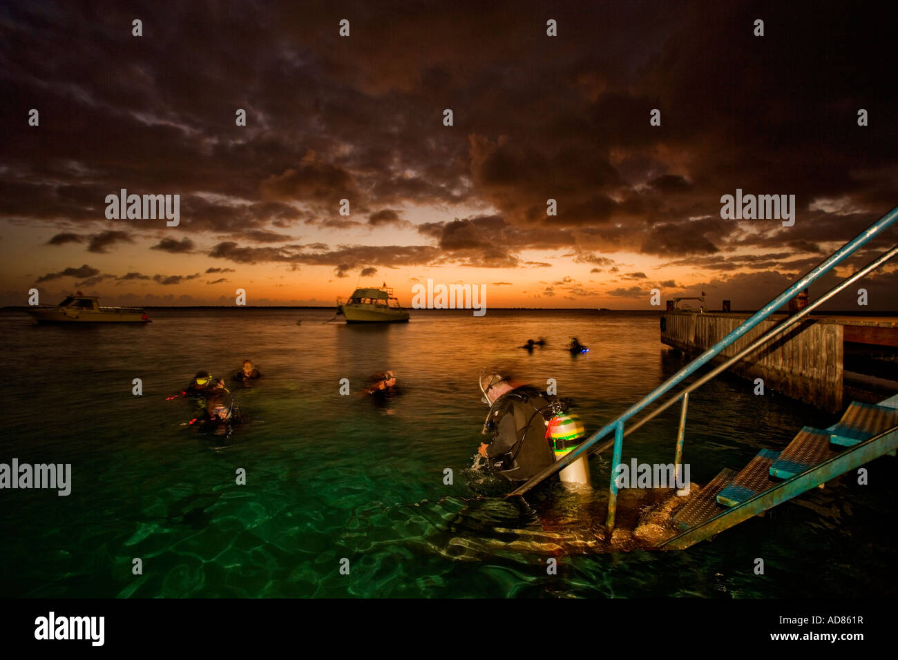 I subacquei per entrare in acqua per immersione notturna, Bonaire, Netherland Antillies Foto Stock