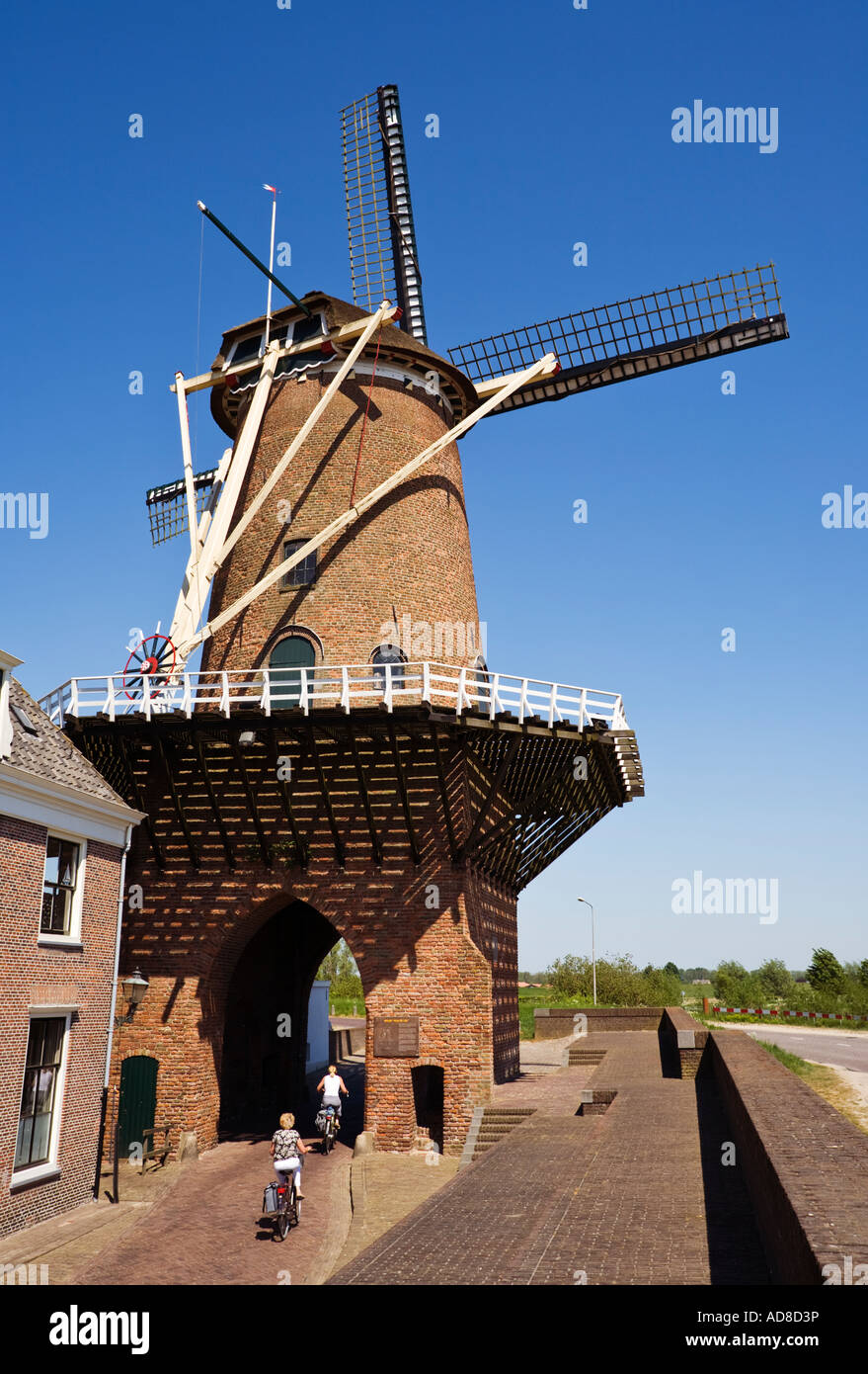Mulino a vento con i ciclisti a Wijk Bij Duurstede, Paesi Bassi, Olanda contro un cielo blu Foto Stock
