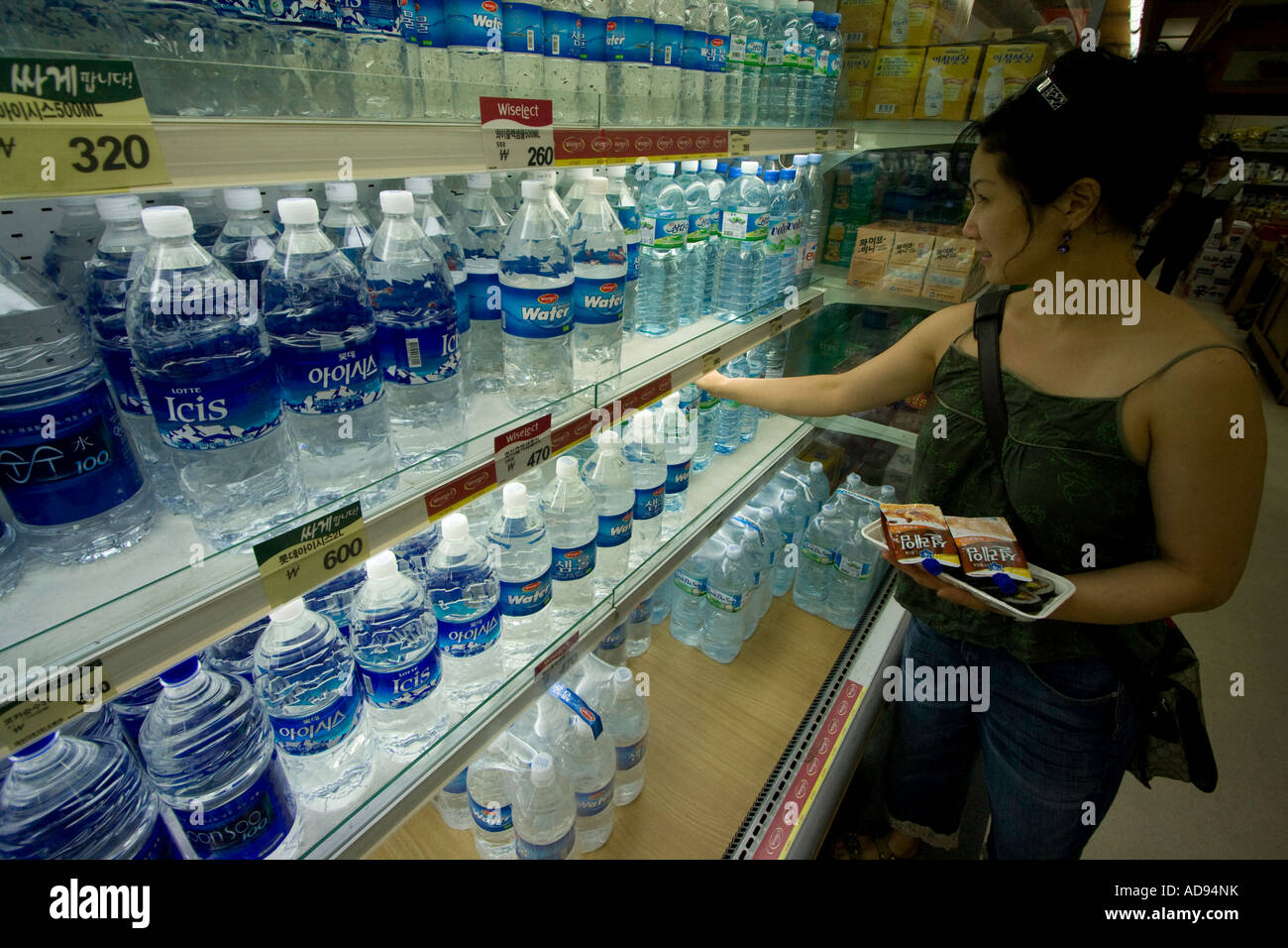 Giovane donna coreana Shopping per acqua in bottiglia in un negozio di alimentari Seoul COREA DEL SUD Foto Stock
