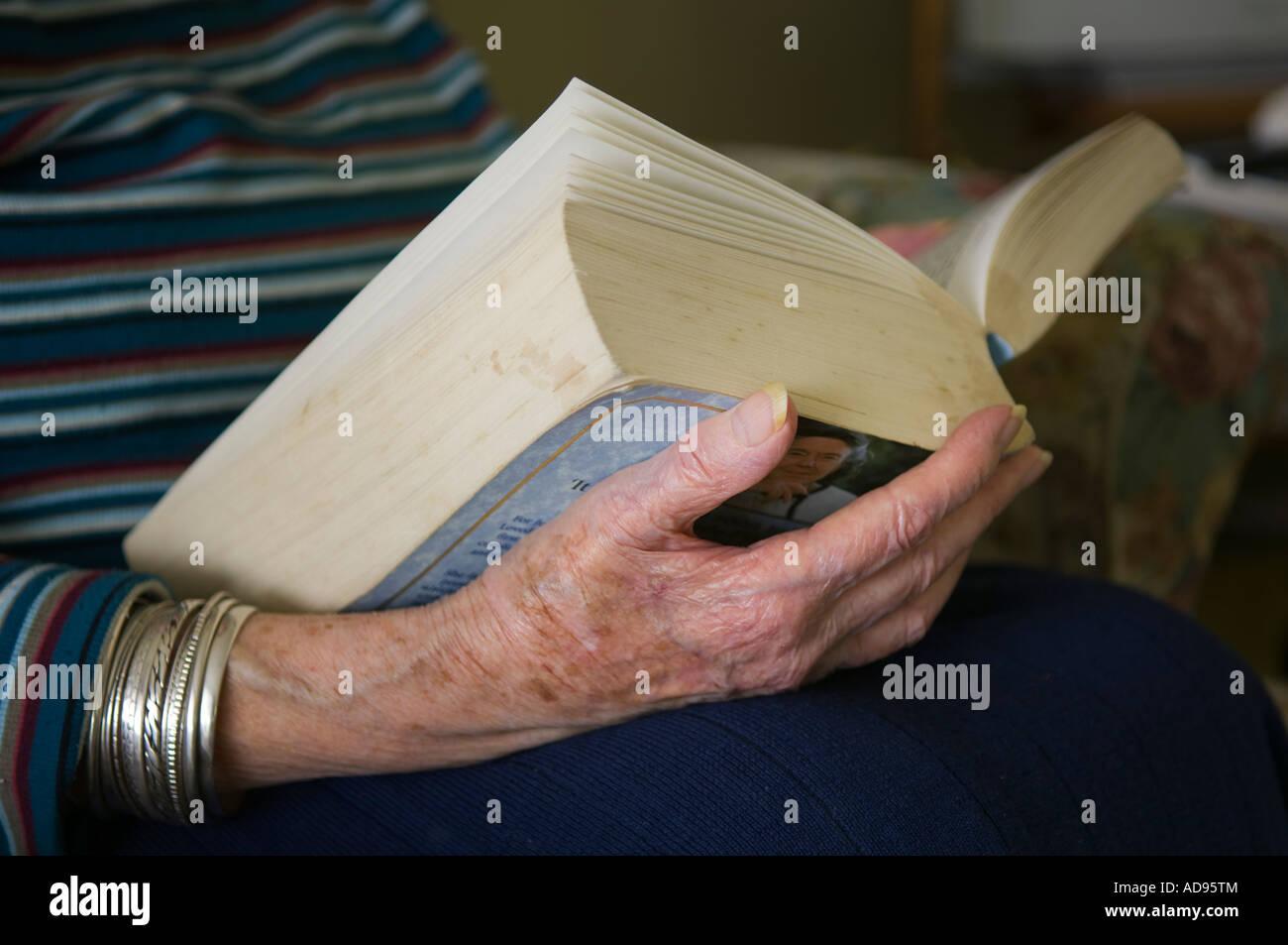 Signora anziana lettura romanzo in brossura Foto Stock