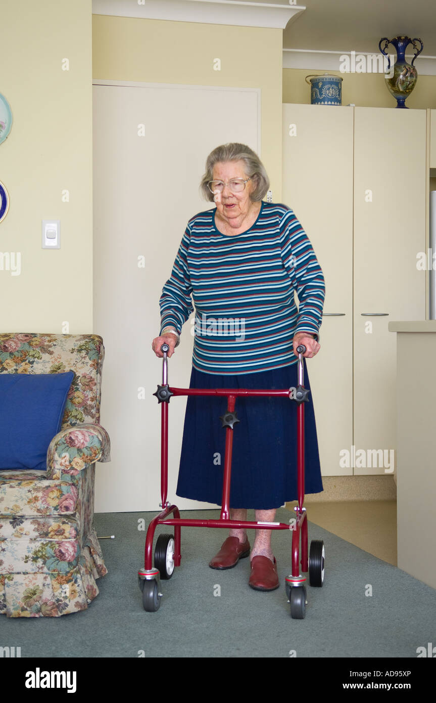 Anziana vedova con telaio a piedi nella sua unità di pensionamento Foto Stock