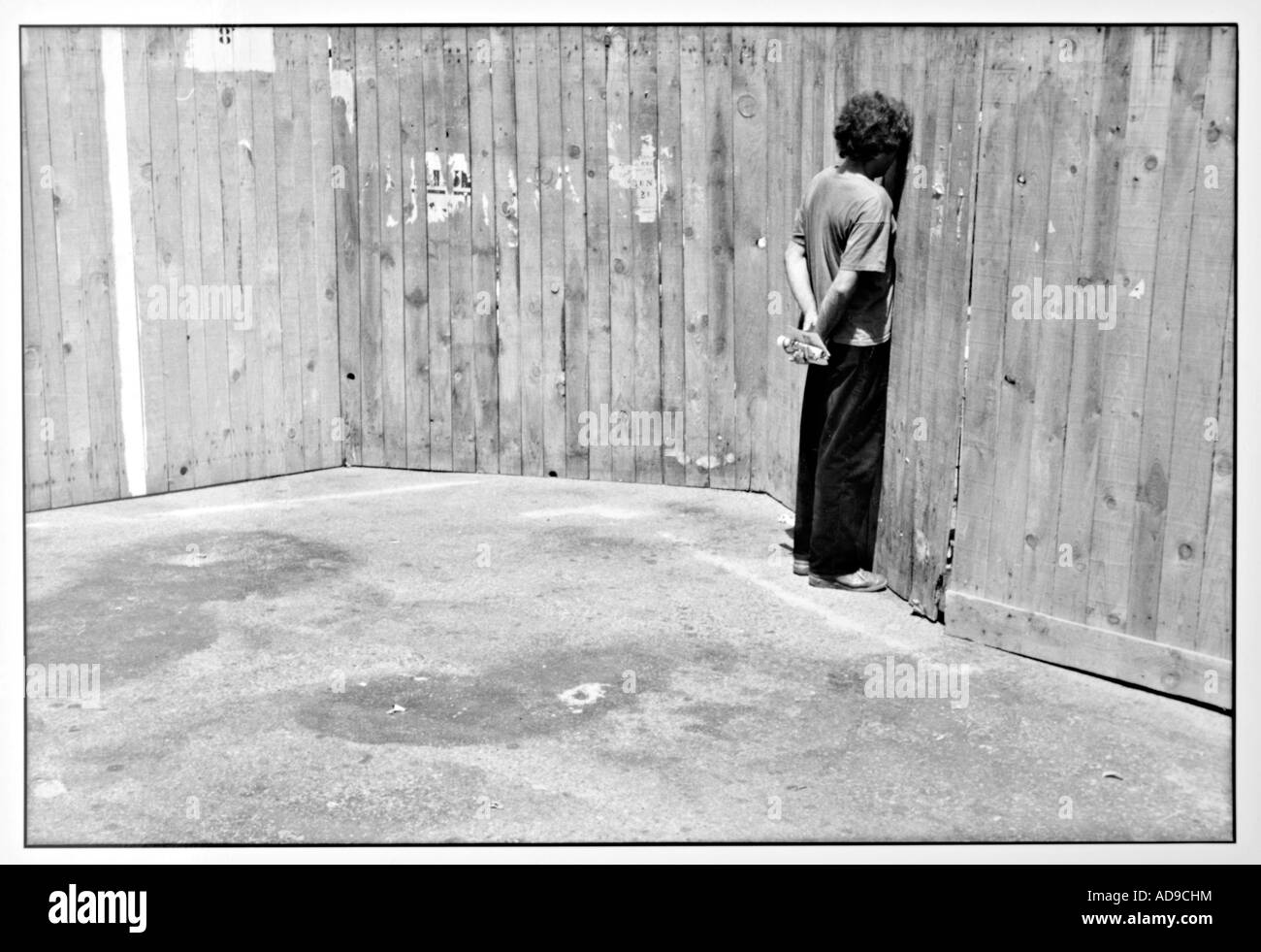 No signor street photography curioso uomo facendo leva tramite una recinzione di legno Foto Stock
