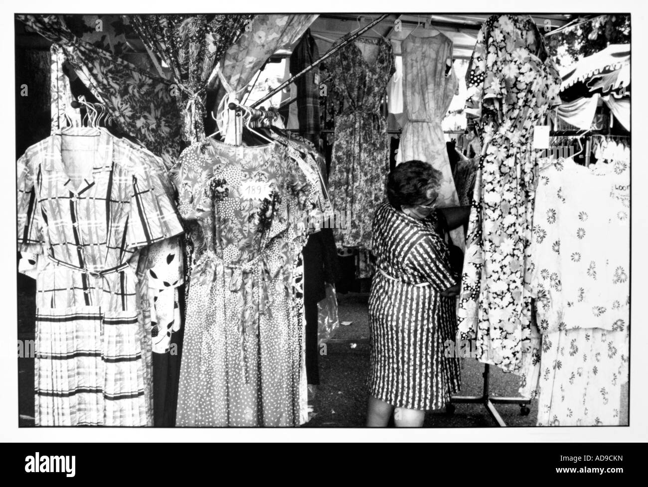 No signor street photography ragazza in un abito modellato in un mercato in stallo con un sacco di abiti modellato Foto Stock