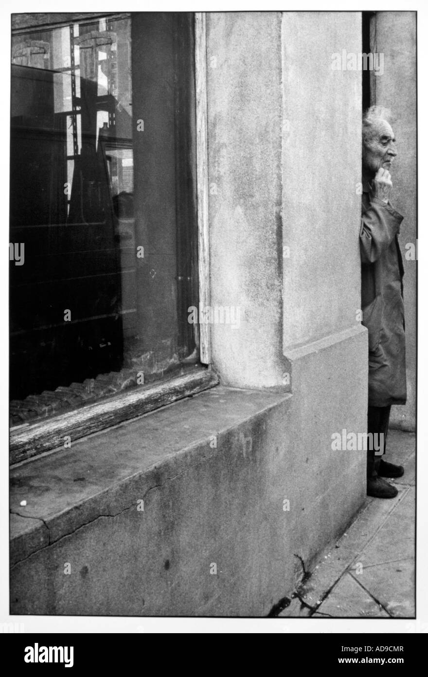 No signor street photography vecchio uomo presso lo sportello anteriore di un vecchio negozio Foto Stock