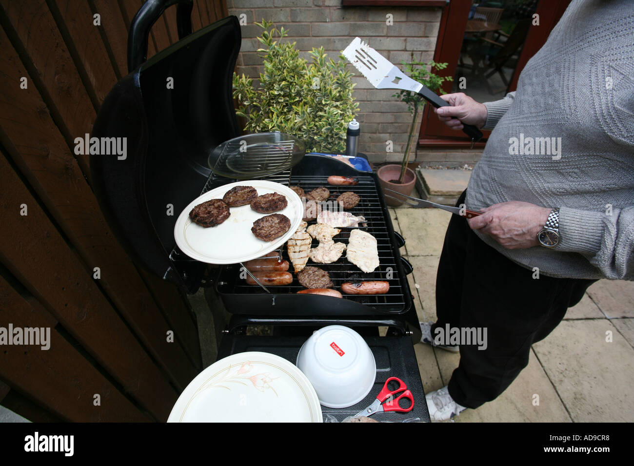 Vari tipi di carne cotti su un gas powered barbecue. Foto Stock