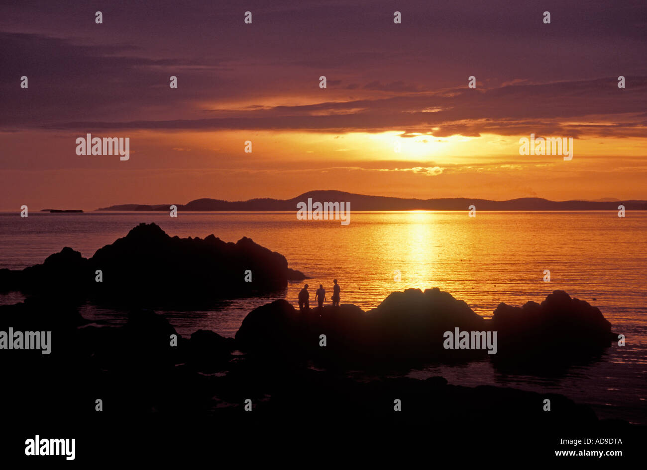 La gente sulle rocce al tramonto a Rosario Beach inganno Pass stato parco Fidalgo Island Washington Foto Stock
