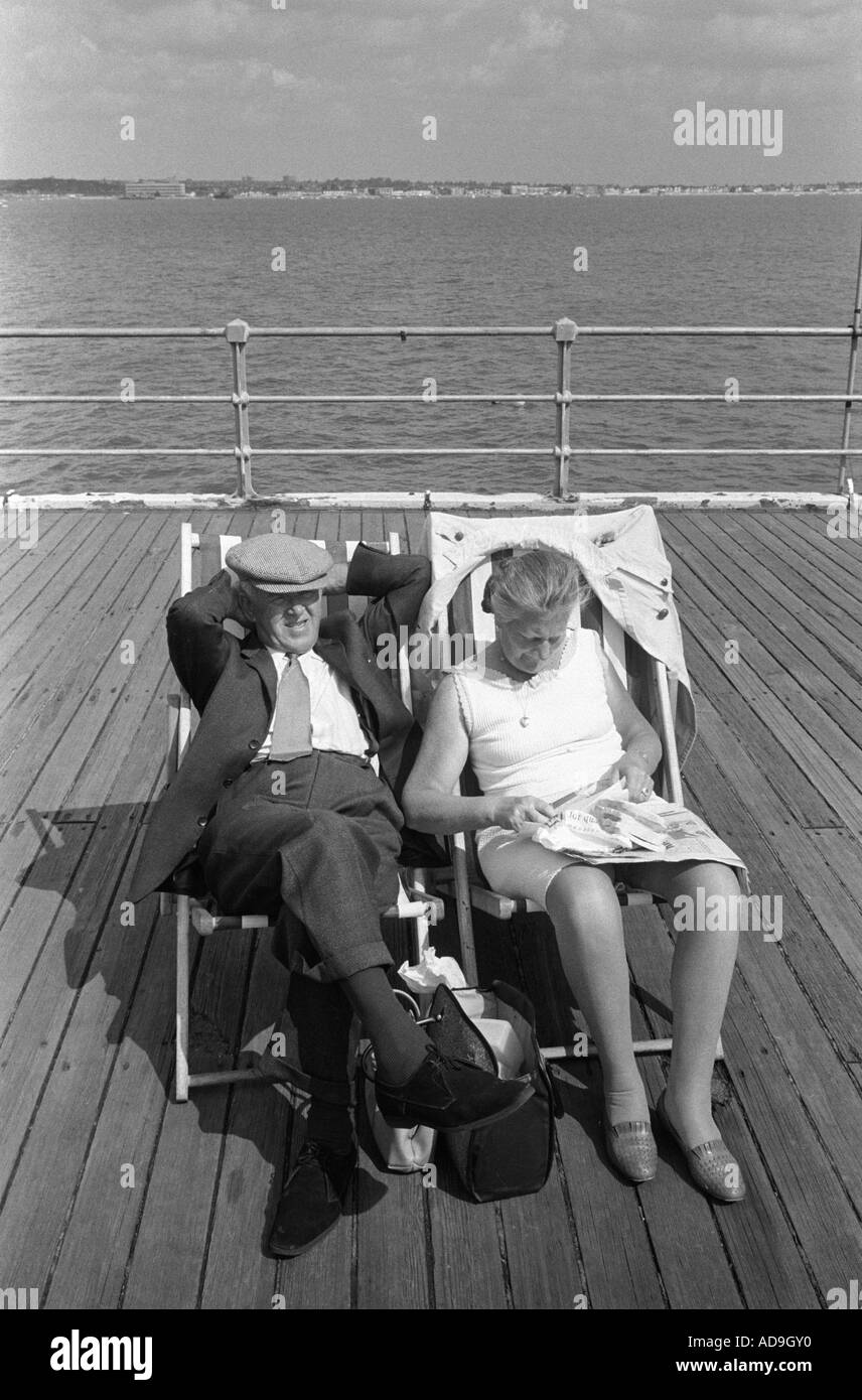 Coppia di anziani in vacanza seduti in sedie a sdraio sul molo. Southend on Sea Essex Inghilterra 1974 1970S UK HOMER SYKES Foto Stock