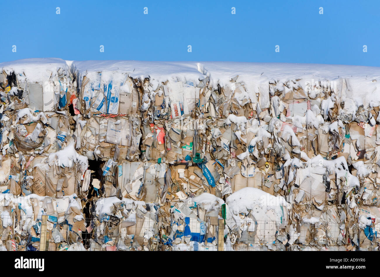 Balle di carta coperta di neve e cartone stoccate all'aperto e in attesa di trasporto per il riciclaggio , Finlandia Foto Stock