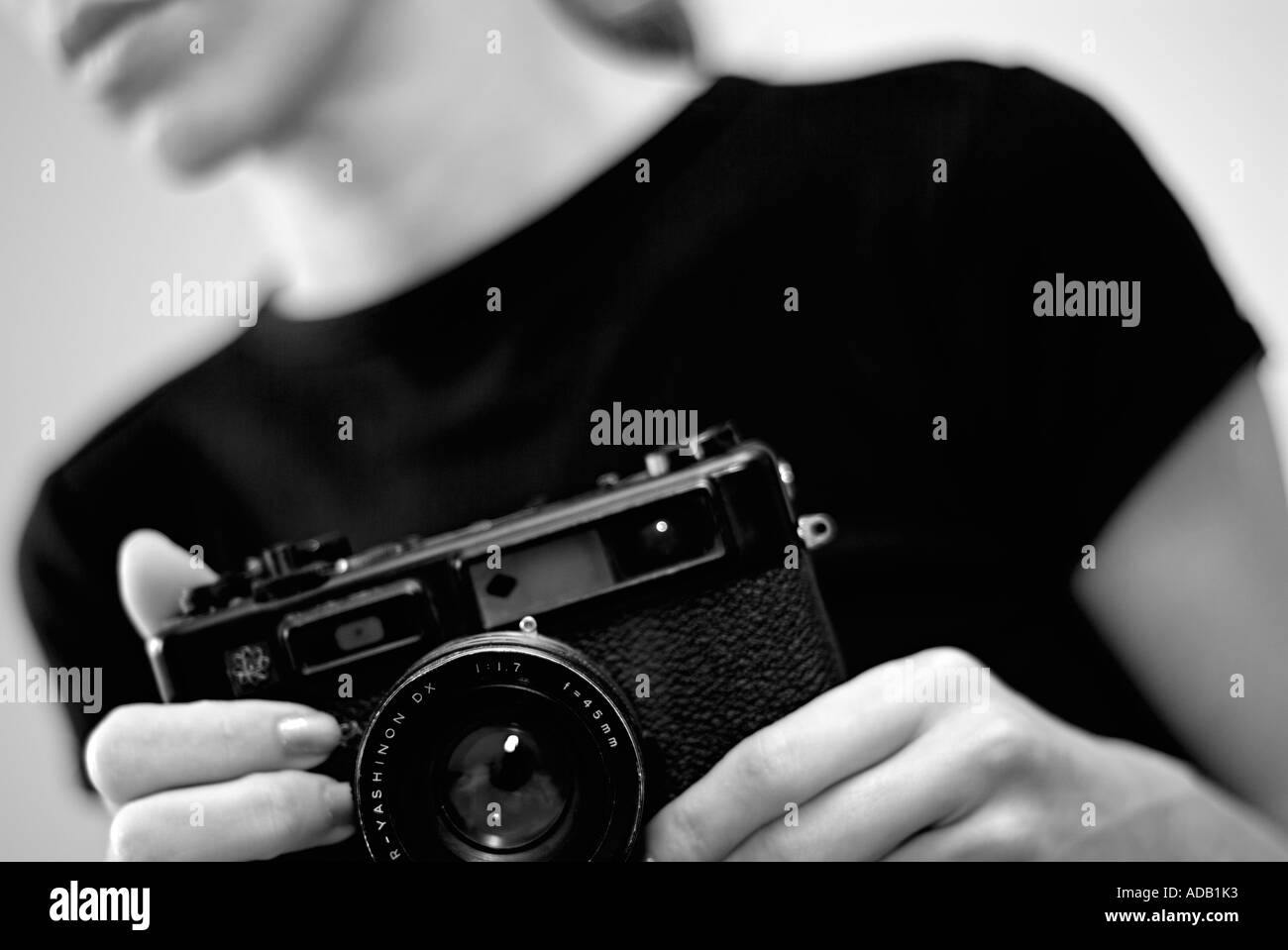Mono Abstract del giovane femmina caucasica utilizzando un telemetro classica fotocamera Foto Stock