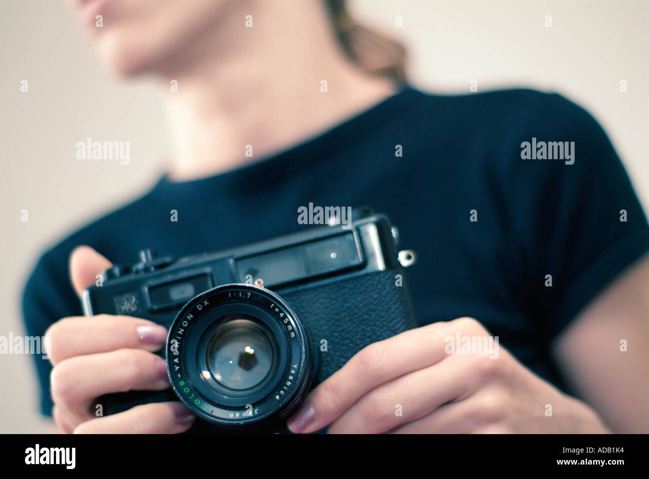 Abstract del giovane femmina caucasica utilizzando un telemetro classica fotocamera Foto Stock