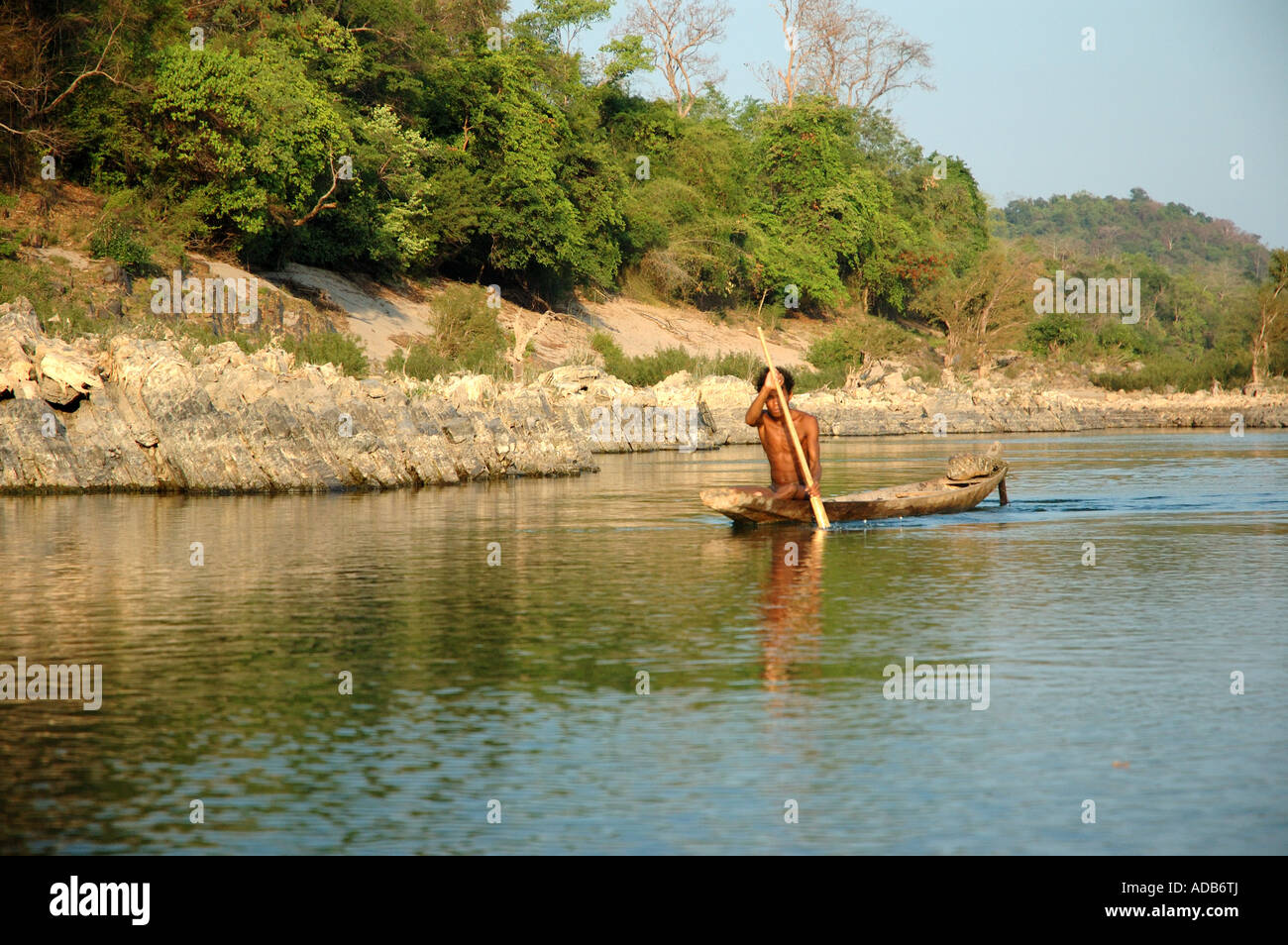 Pescatore in una canoa sul tranquillo fiume Mekong al crepuscolo in Laos, quattro Mille Isole Foto Stock