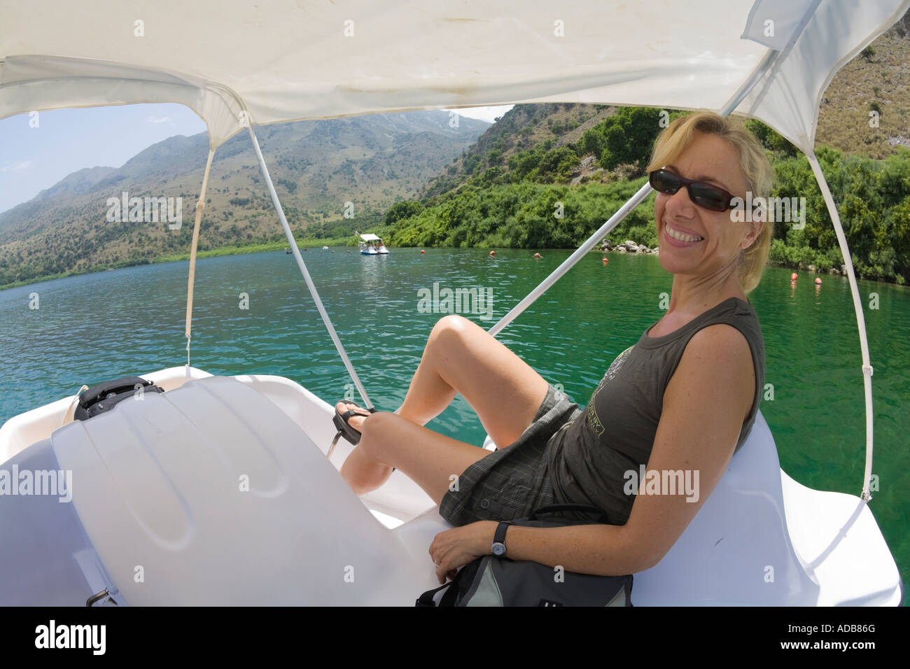 Una donna bionda nel suo fourties in un pedalò sul Lago di Kournas / Creta / Grecia Foto Stock