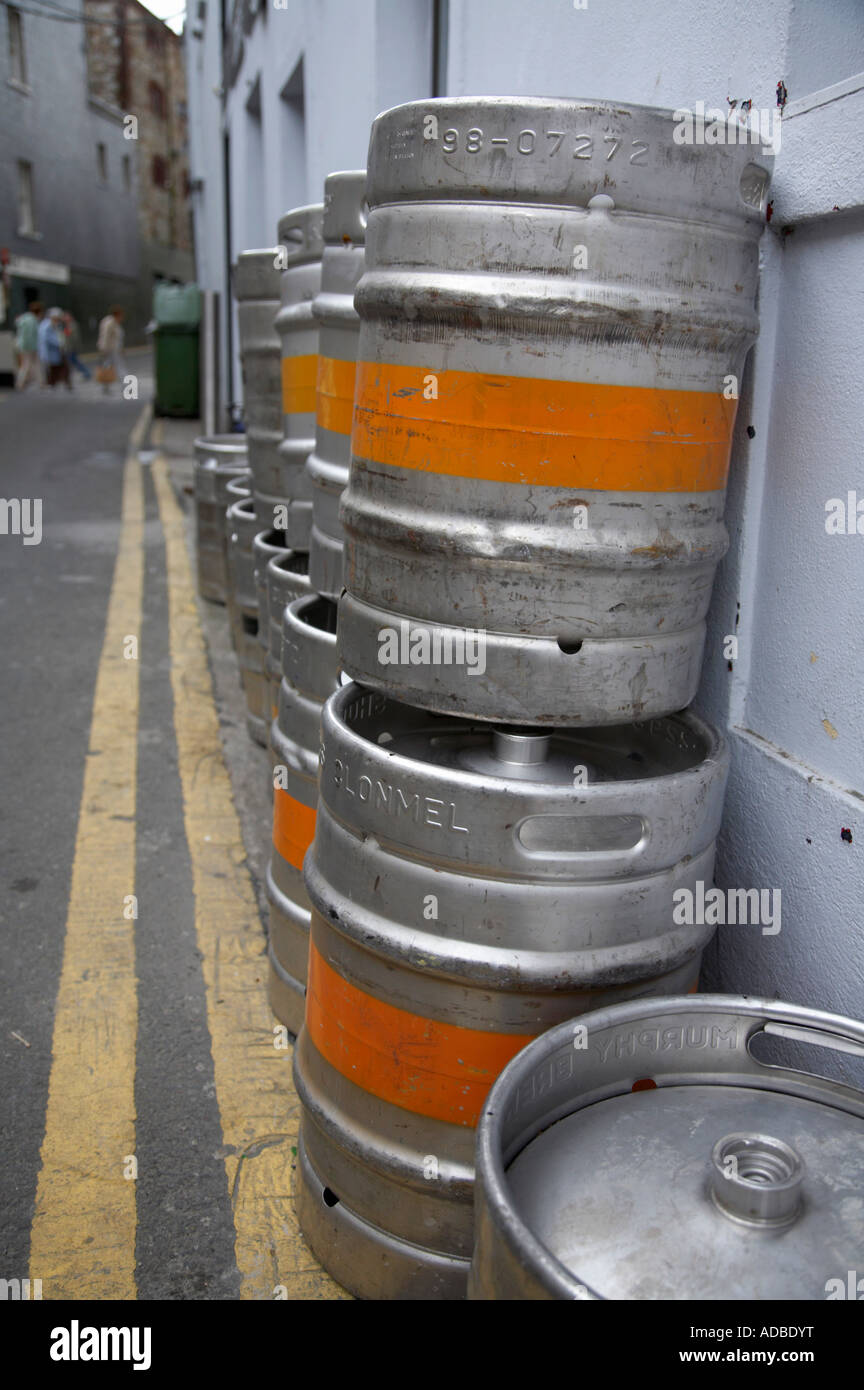 Pila di barili di birra al di fuori del pub nel vicolo con doppio giallo linee nella città di Wexford in Irlanda Foto Stock