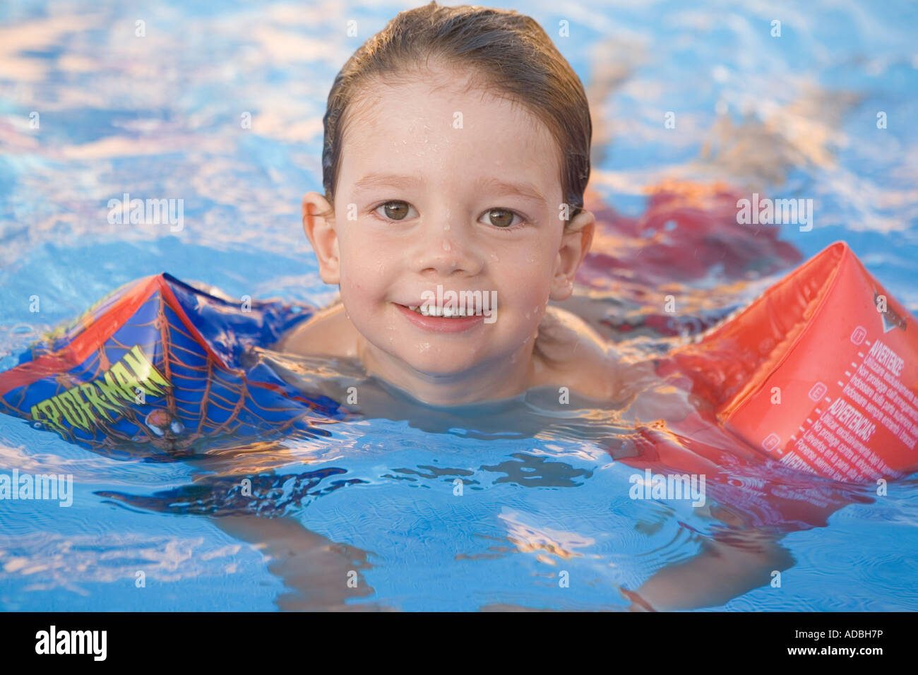 Ragazzo di imparare a nuotare con floater del braccio Foto Stock
