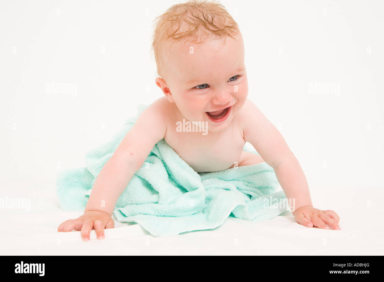 Happy baby avvolto in un asciugamano blu Foto Stock