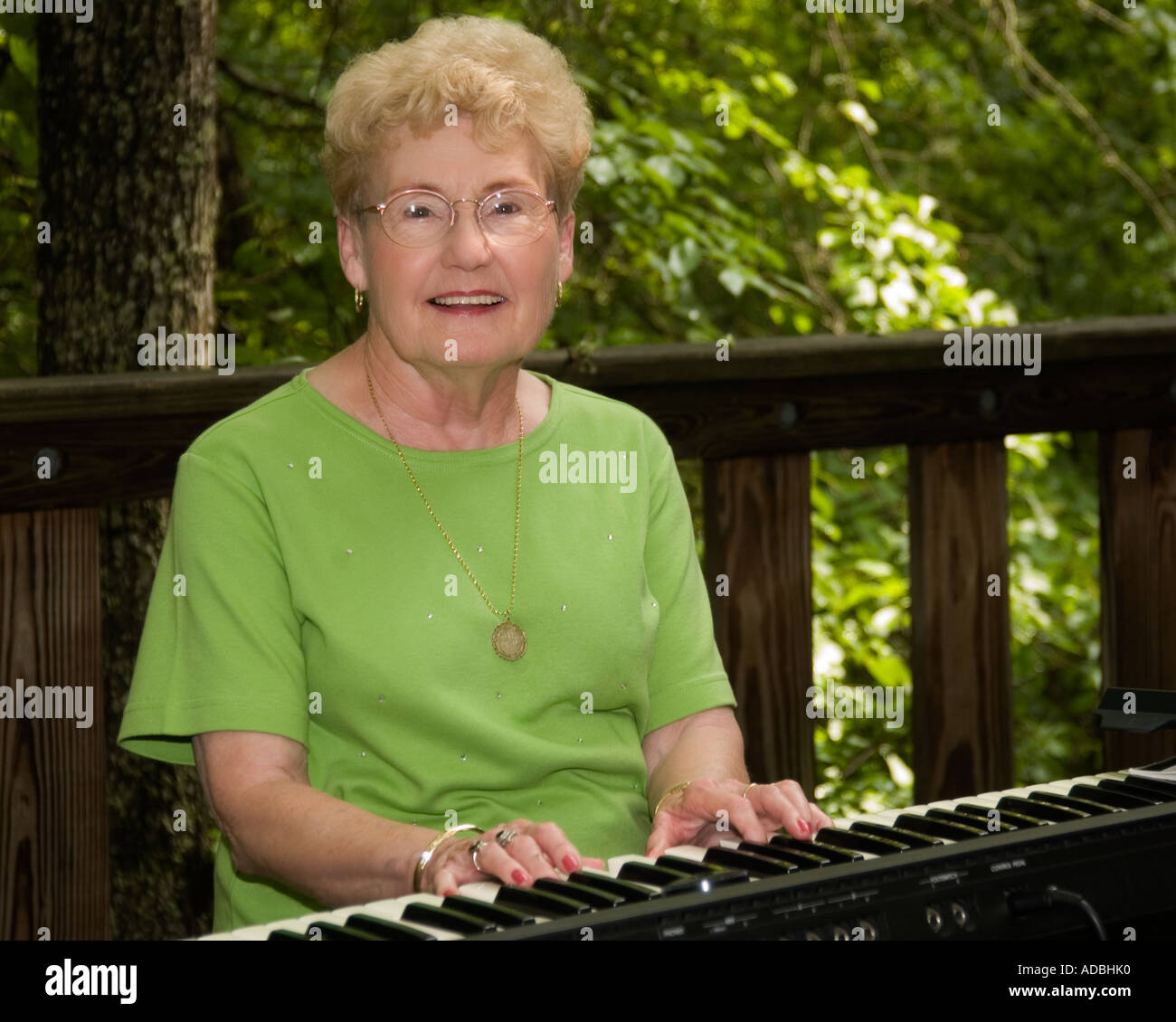 Una donna caucasica in pensione (65-70) che suona una tastiera fuori dagli Stati Uniti. Foto Stock