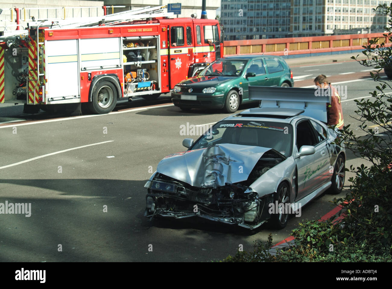 West London stropicciata estremità anteriore della vettura dopo incidente stradale con frequentando il fuoco al di là del motore Foto Stock