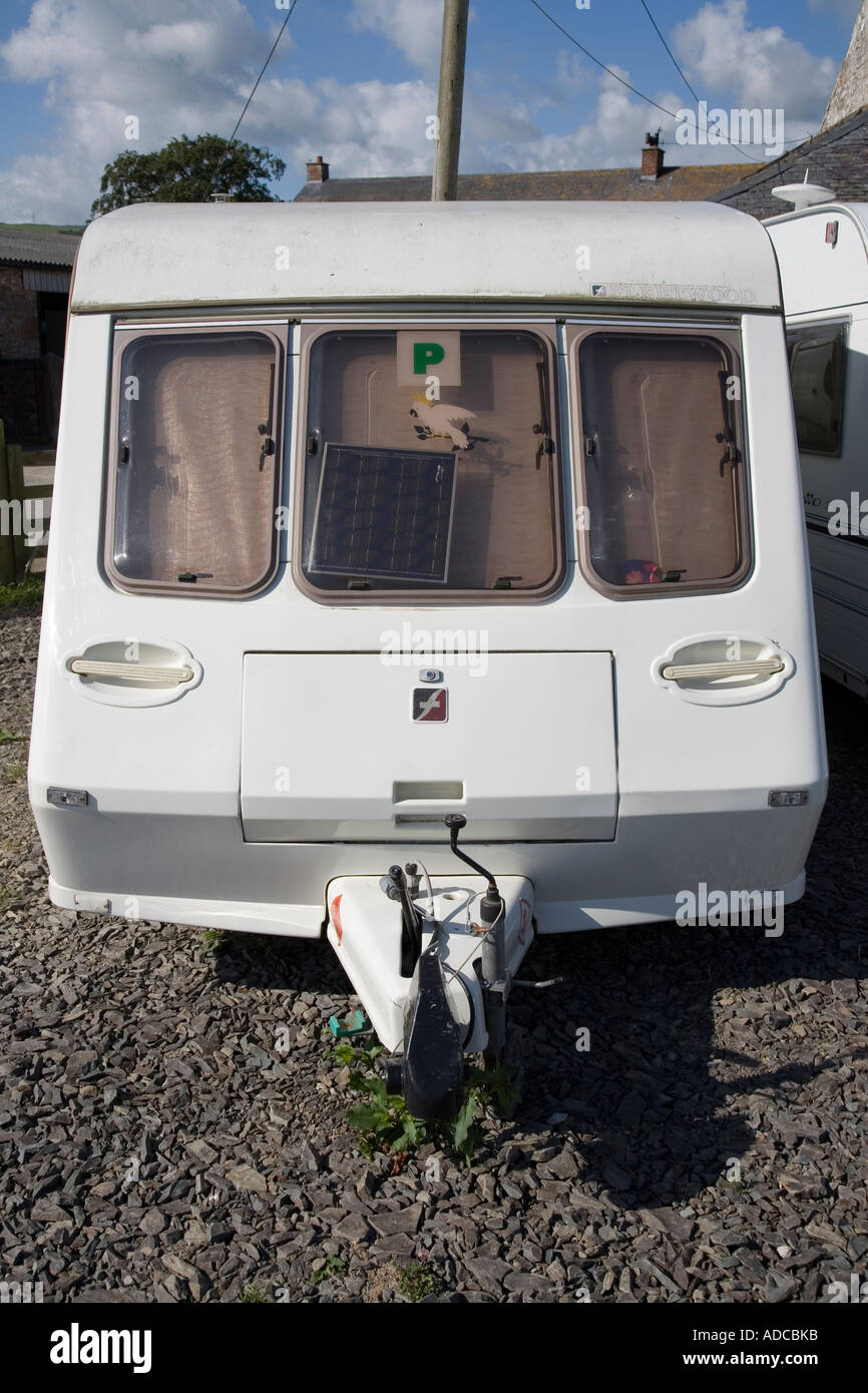 Caravan in deposito al campeggio con pannello solare nella finestra per mantenere carica la batteria del Galles REGNO UNITO Foto Stock