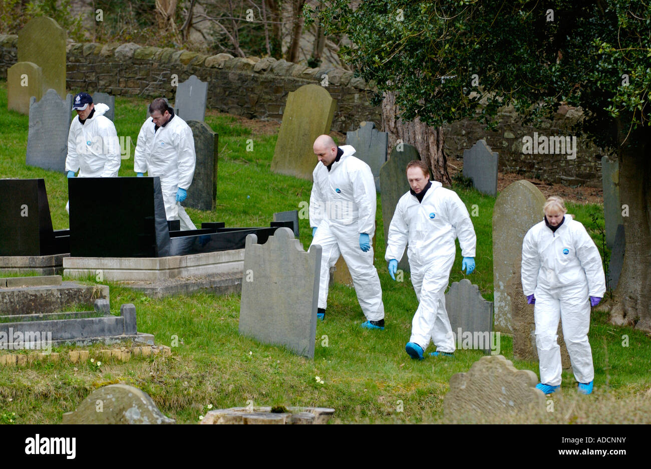 I funzionari di polizia del cimitero di ricerca dopo l omicidio di padre Paolo Bennett pugnalato a morte nella motivazione della sua chiesa Wales UK Foto Stock
