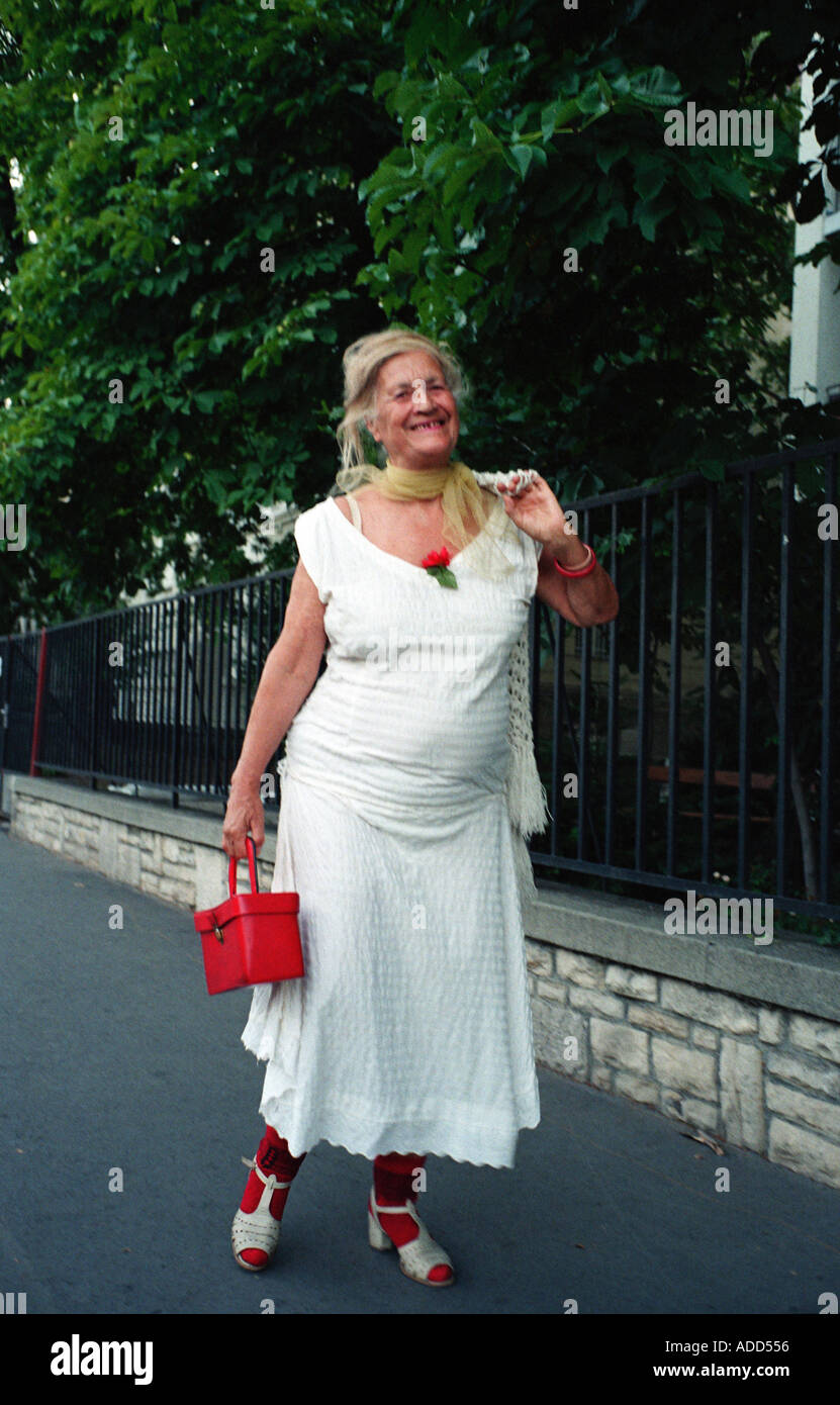 Un vecchio sorridente ragazza in un abito bianco e rosso passeggiate  accessori fino all'elegante Andrasszy Street a Budapest Ungheria Foto stock  - Alamy