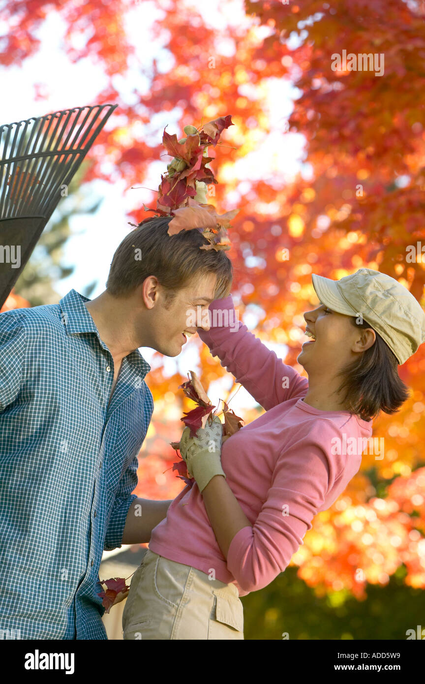 Felice inizio 30's Caucasian giovane giocando in foglie di autunno Foto Stock