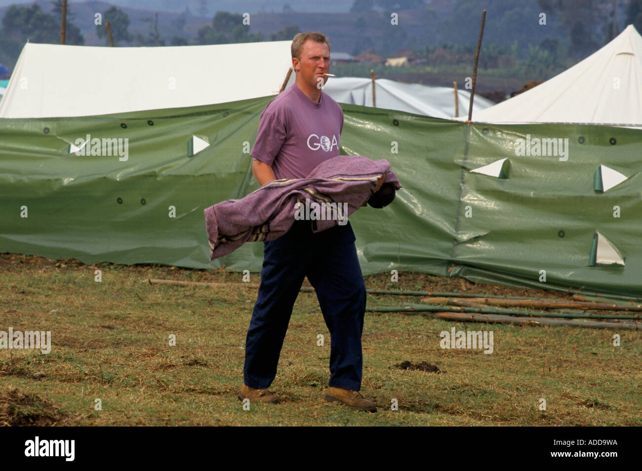 Kibumba Camp orfanotrofio Goma, luglio 1994. Un obiettivo aiuto lavoratore svolge un corpo di un giovane vittima di dissenteria. Foto Stock