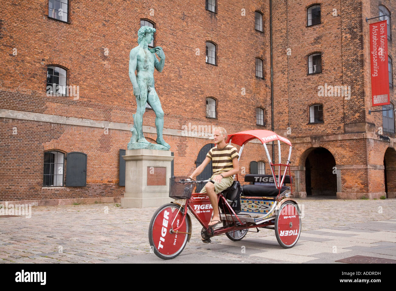 Un pedicab passa una replica di Michelangelos David al di fuori del Statens Museum Kunst, Copenhagen, Danimarca Foto Stock