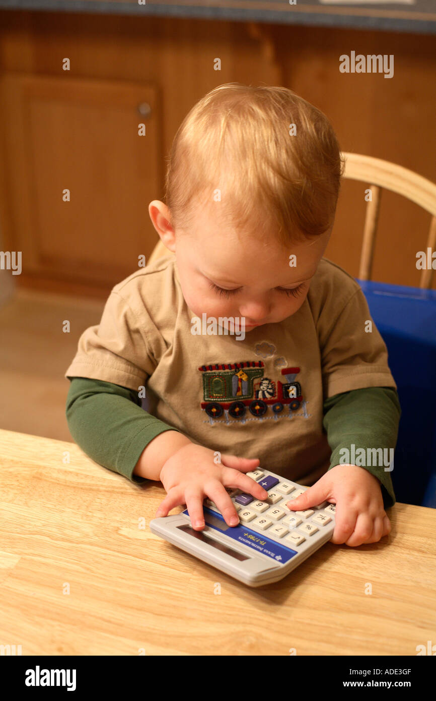 Un anno vecchio ragazzo giocando con la calcolatrice Foto Stock