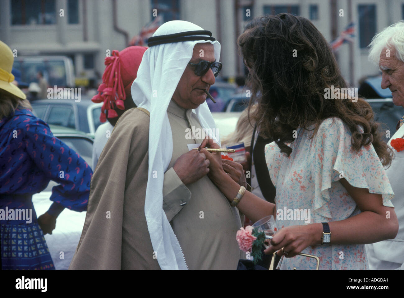 La ragazza scrive il suo numero di telefono per un ricco arabo su un pezzo di carta. Prendere una donna, organizzare un incontro. Epsom Downs Inghilterra anni '1985 1980 Regno Unito Foto Stock