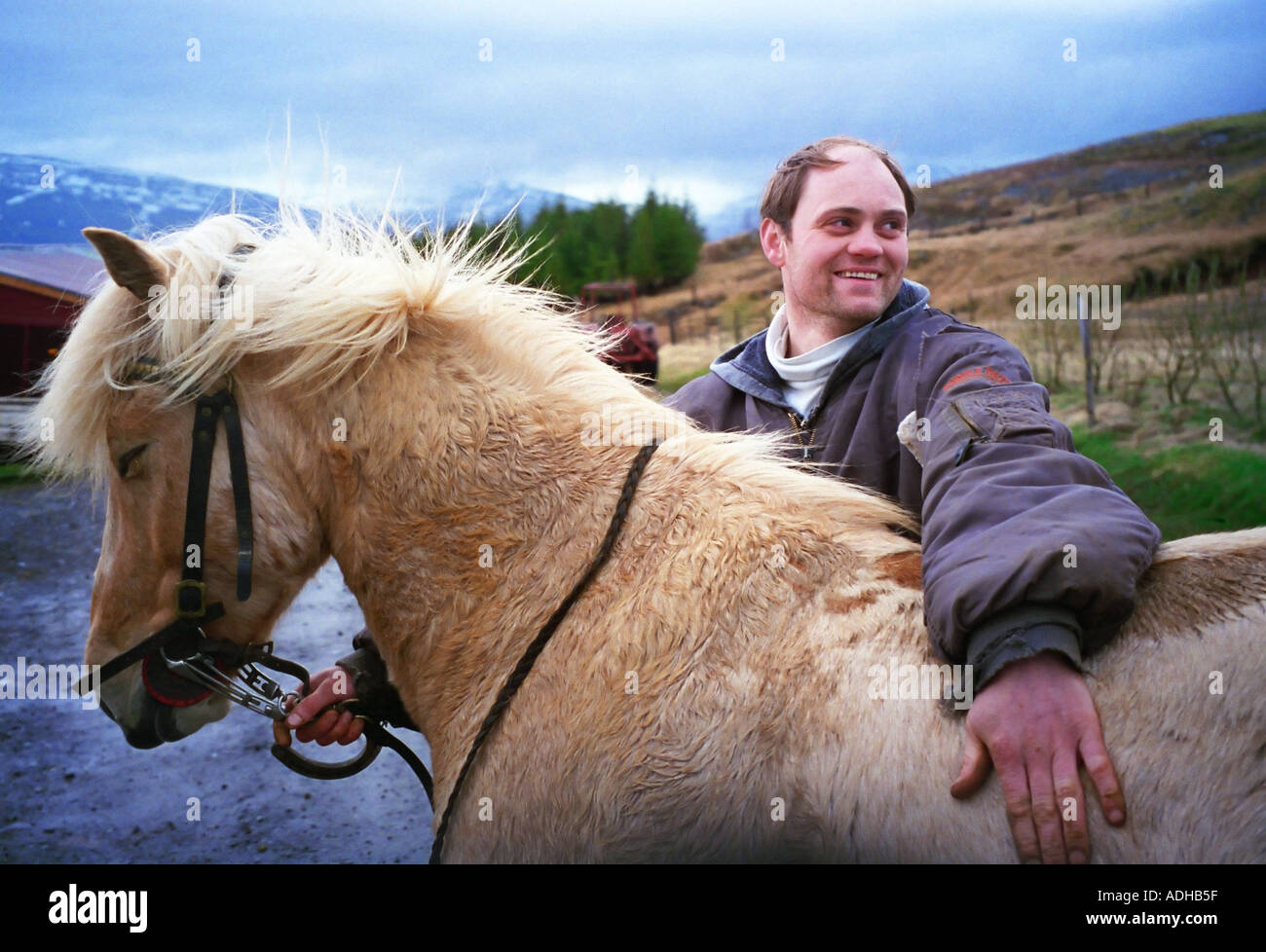 Un bracciante agricolo condivide un sorriso con uno dei Cavallini islandesi nella sua cura Cavallini islandesi sono famosi per avere un quinto andatura Foto Stock