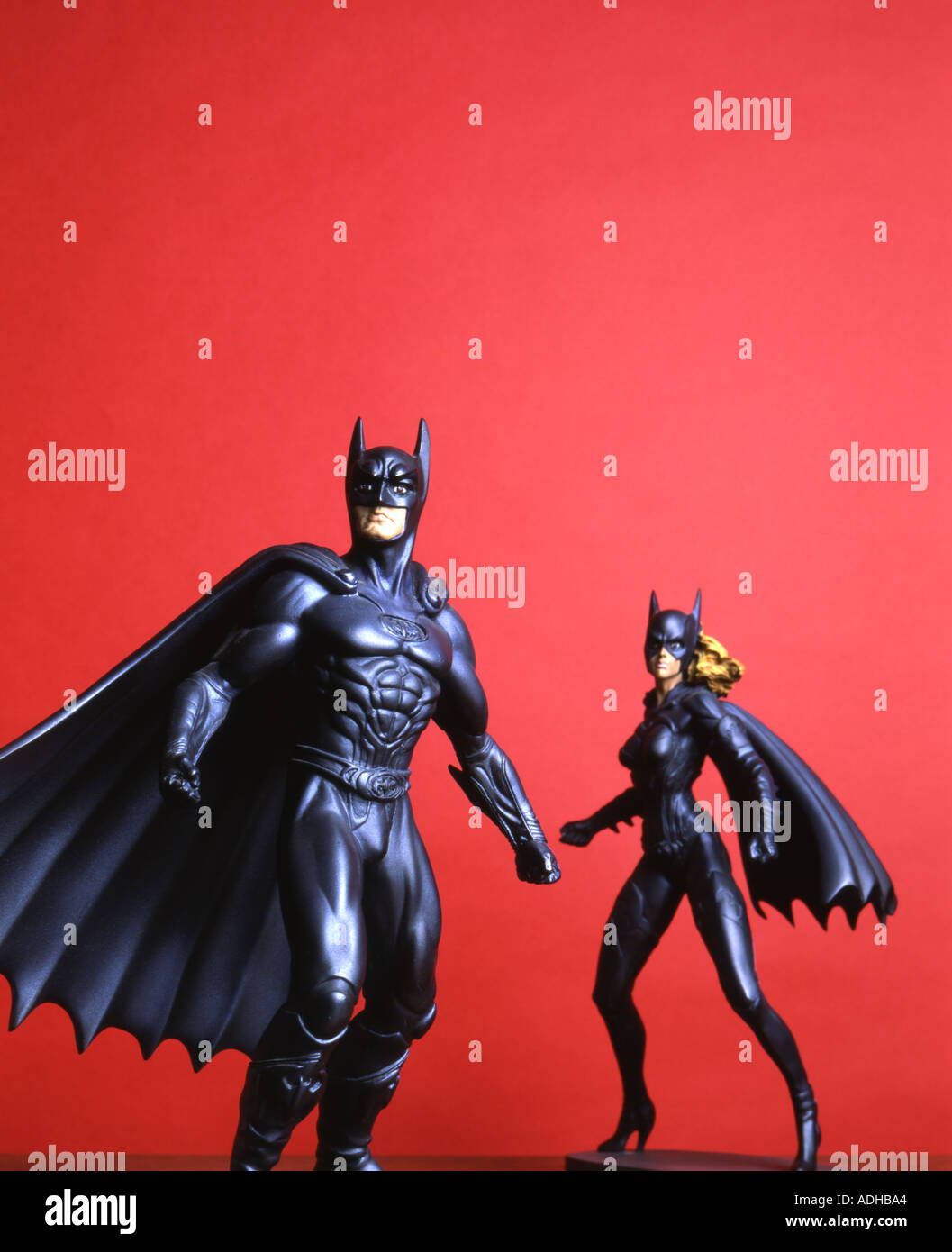 Batman e batwoman figurine su sfondo rosso Foto Stock