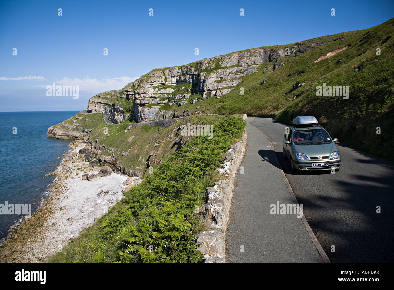 Donna alla guida di auto su Marine Drive intorno alla costa di Great Orme Llandudno Wales UK Foto Stock