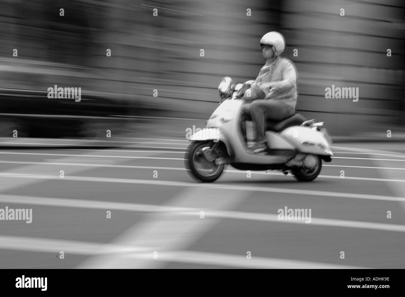 Uomo su una Vespa attraverso il centro di Londra Foto Stock