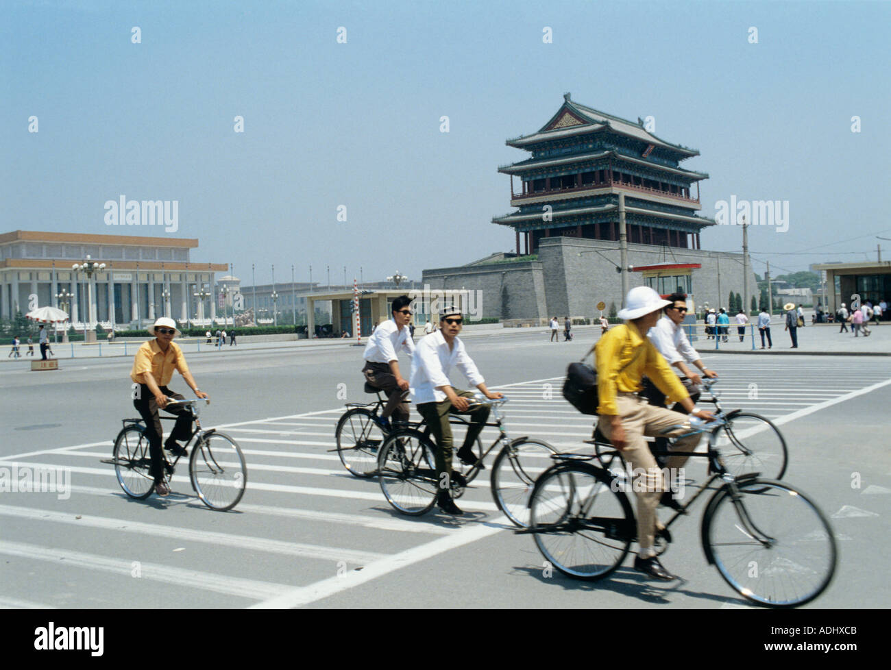 I ciclisti di Pechino passano davanti a una porta della città vecchia. Sullo sfondo è la Tomba di Mao TSE Tung Foto Stock