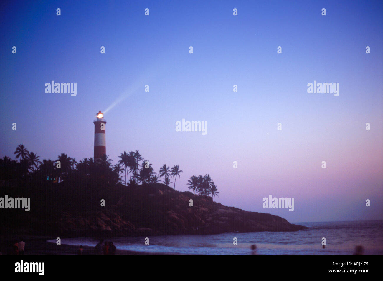 Spiaggia Kovalam Light house accesa al di sopra di palme al tramonto dopo il tramonto trivandrum thiruvananthapuram kerala India del sud asia - rhs 70897 Foto Stock